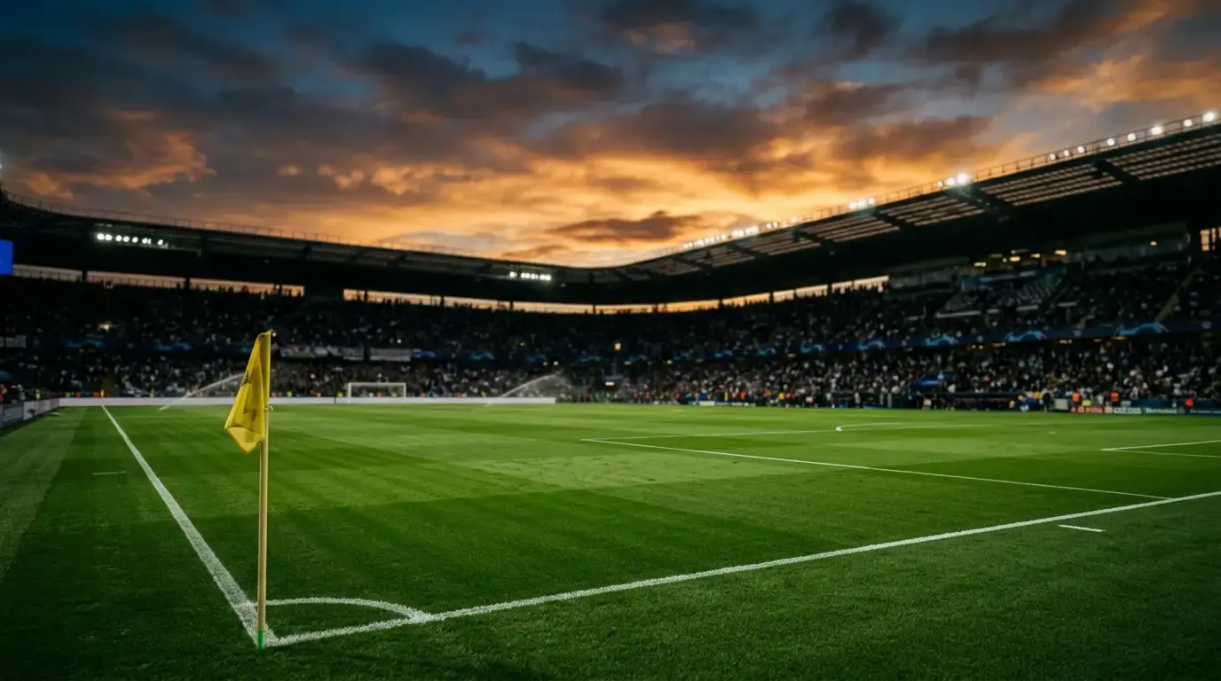 Prázdne futbalové ihrisko pod večerným nebom, v pozadí rozmazaný moderný štadión s reflektormi, atmosféra veľkého štvrťfinálového zápasu